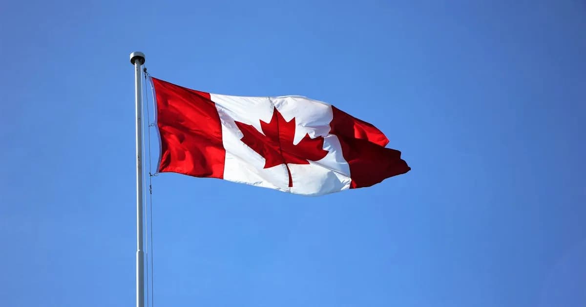 Canadian flag waving against a blue sky