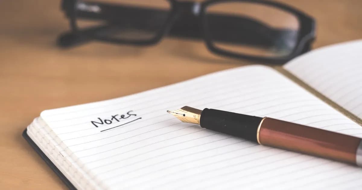 Notebook with pen and glasses on a desk for studying